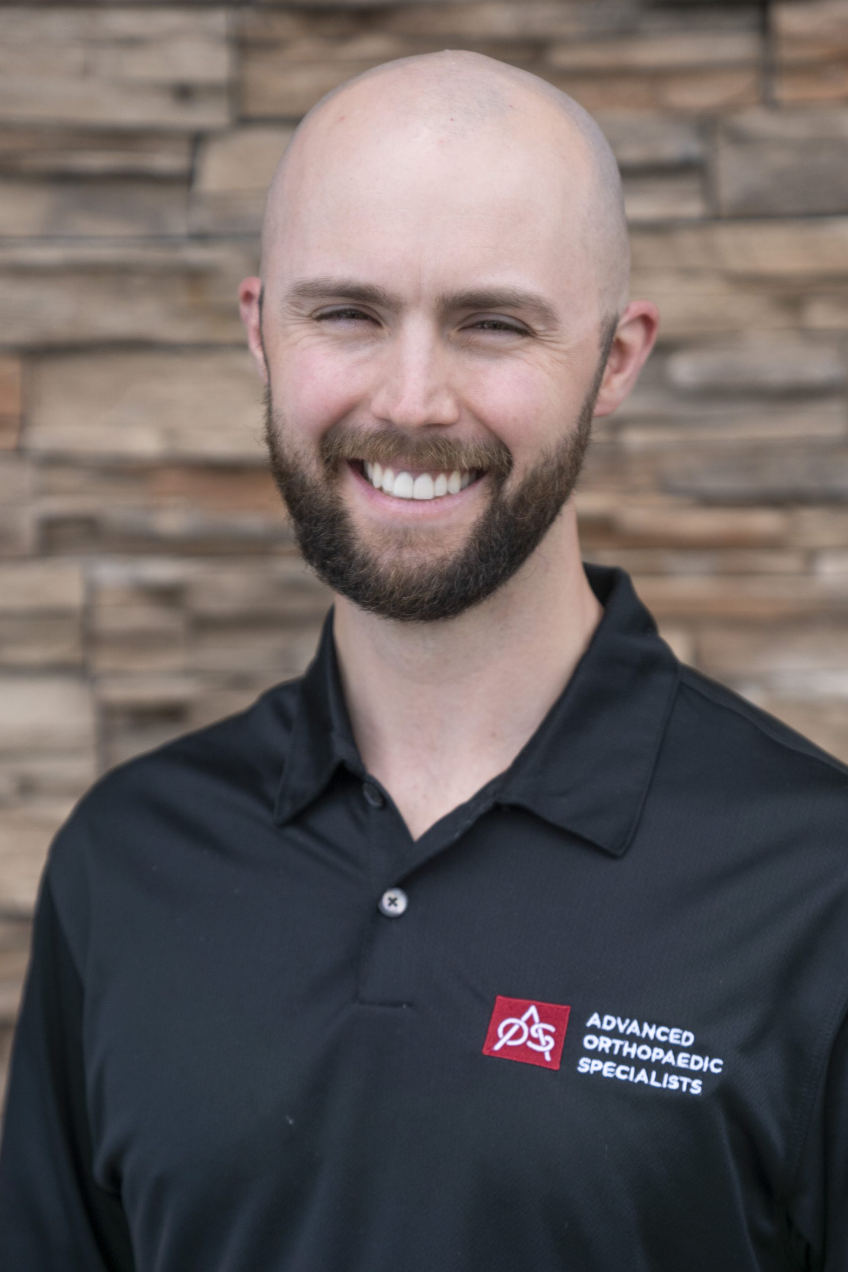 Smiling person in Advanced Orthopaedic Specialists shirt.